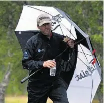  ??  ?? Cover-up: Northern Ireland’s Michael Hoey, left, tries to grab a snack, while Australian Scott Arnold also takes shelter from the elements