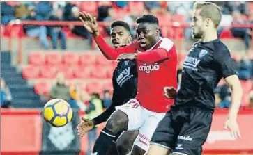  ?? LFP ?? El grana Dongou disputa un balón con dos jugadores del Huesca en el Nou Estadi