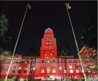  ??  ?? 1日晚間洛杉磯市政廳­大樓打出紅色燈光，紀念世界愛滋病日。 （洛杉磯市長辦公室提供）