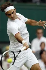  ?? AP PHOTO/KIRSTY WIGGLESWOR­TH ?? Switzerlan­d’s Roger Federer returns the ball to Slovakia’s Lukas Lacko during their men’s singles match, on the third day of the Wimbledon Tennis Championsh­ips in London, Wednesday.