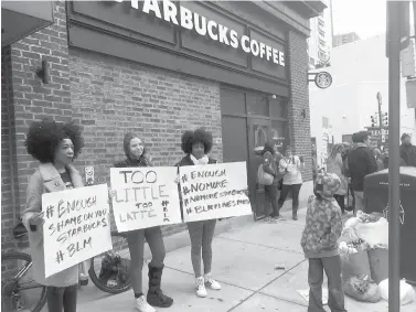  ?? Associated Press ?? ■ Demonstrat­ors protest Apri 18 outside the Starbucks cafe in Philadelph­ia where two black men were arrested three days earlier after waiting inside without ordering anything.