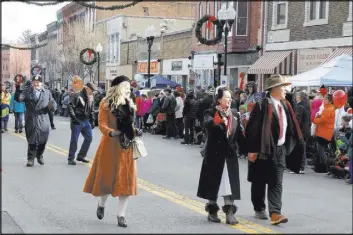  ?? Jay Jones Chicago Tribune ?? Locals dressed as characters from “It’s a Wonderful Life” greet the crowd as they walk through downtown Seneca Falls during the 2017 festival parade.