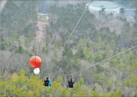  ?? TIM MARTIN/THE DAY ?? People ride the HighFlyer Zipline at Foxwoods Resort Casino on Thursday, when there was a ribbon cutting ceremony and media tour. The zipline starts 350 feet off the ground on top of Fox Tower and ends a mile away, at the Mashantuck­et Pequot Museum &...