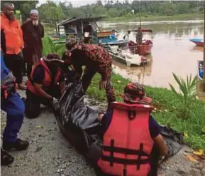  ?? (Foto ihsan JBPM Perak) ?? Pasukan penyelamat membawa naik mayat Mohamad Nor Amirulhamz­ah yang ditemukan terapung di tepian Sungai Perak.