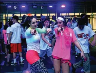  ?? PHOTOS BY BOB RAINES ―DIGITAL FIRST MEDIA ?? Teens have fun dancing under black lights and strobe lights during SouderTHON at Souderton Area High School Friday.