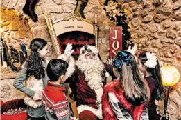  ?? DAVID VAAKNIN/FOR THE WASHINGTON POST ?? Issa Kassissieh, 40, greets children at Santa's House in Jerusalem. “I am the only official Santa of the Holy Land.”