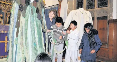  ??  ?? From left, Michele Crooks, Jessie and Jeremy Lin and Samantha Stephen take a good look at some specially-created garments, designed to encourage reflection on Biblical passages, on display in St Mary’s Church, Hinckley, throughout Lent 2017.
