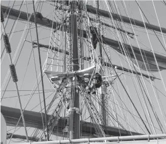  ??  ?? Crew members climb the masts to set the sails.