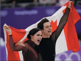  ?? AP PHOTO/DAVID J. PHILLIP ?? Tessa Virtue and Scott Moir of Canada celebrate during the venue ceremony after winning the ice dance, free dance figure skating final in the Gangneung Ice Arena at the Winter Olympics in Gangneung, South Korea, Tuesday.