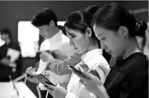  ?? SEONGJOON CHO / BLOOMBERG ?? Attendees try out Samsung Electronic­s Co’s Galaxy Note 8 smartphone­s during a media event in Seoul, South Korea.