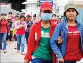  ?? LINA PHA ?? Employees leave a garment factory in Phnom Penh’s Meanchey district after work.