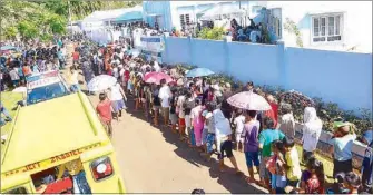  ??  ?? Camotes residents line up for the INC’s ‘Lingap sa Mamamayan’ food aid distributi­on and medical mission at the INC house of worship in Barangay Himensulan.