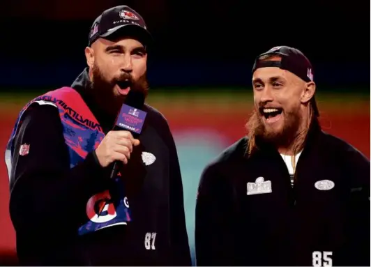  ?? CHRIS UNGER/GETTY IMAGES ?? Tight ends Travis Kelce of the Chiefs and George Kittle of the 49ers enjoy the stage during Super Bowl opening night.