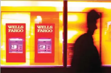  ?? TAYLER SMITH/THE NEW YORK TIMES ?? Wells Fargo ATMs in New York, on January 12. The bank was ordered by a federal regulator to pay $5.4 million to a manager who was fired in 2010 after informing supervisor­s and a bank ethics hotline about what he thought was fraudulent behaviour.