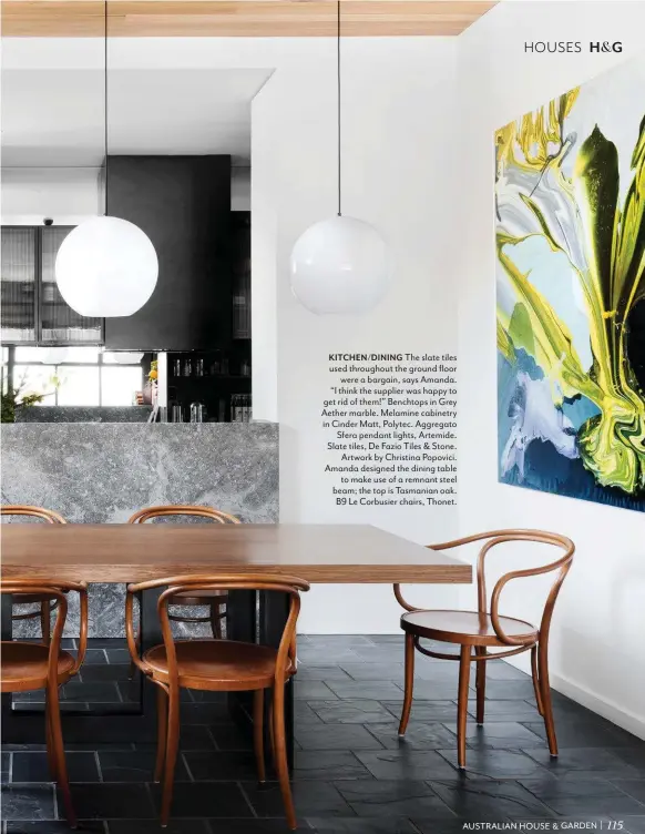  ??  ?? KITCHEN/DINING The slate tiles used throughout the ground floor were a bargain, says Amanda. “I think the supplier was happy to get rid of them!” Benchtops in Grey Aether marble. Melamine cabinetry in Cinder Matt, Polytec. Aggregato Sfera pendant lights, Artemide. Slate tiles, De Fazio Tiles & Stone. Artwork by Christina Popovici. Amanda designed the dining table to make use of a remnant steel beam; the top is Tasmanian oak. B9 Le Corbusier chairs, Thonet.