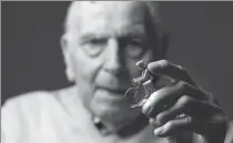  ?? AFP ?? Coste, the oldest living French Olympic champion, poses with a figurine of a cyclist at his home in Paris on June 30.