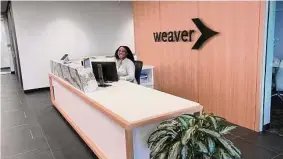  ?? Photos by Katherine Feser/Staff ?? A receptioni­st greets guests on the 11th floor of Weaver’s new office at Five Post Park. Founded in 1950, the firm employs more than 900 people.