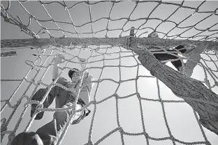  ?? Staff file photo by Evan Lewis ?? n Caleb Kisselburg, 9, of Texarkana, Ark., races up and over a rope cargo net obstacle at the 2016 Scout-O-Rama. About 2,000 scouts from Texas, Arkansas, Louisiana and Oklahoma attended the three-day event. This year’s event begins Friday at Spring...