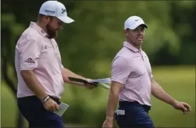  ?? GERALD HERBERT — THE ASSOCIATED PRESS ?? Rory Mcilroy, right, and teammate Shane Lowry walk down the first fairway during the first round of the PGA Zurich Classic at TPC Louisiana on Thursday in Avondale, La.