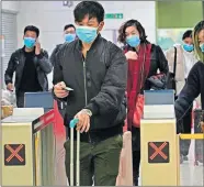  ??  ?? Passengers wearing protective face masks arrive at the high-speed train station in Hong Kong on Tuesday. Hong Kong's leader has announced that all rail links to mainland China will be cut starting Friday as fears grow about the spread of a new virus. [VINCENT YU/AP]