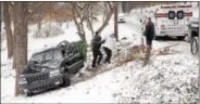  ?? TOM KELLY III — FOR DIGITAL FIRST MEDIA ?? A Goodwill paramedic helps a woman up a hill after North Coventry police and ambulance responded to a crash involving an SUV that slid off snow-covered Temple Road Thursday.