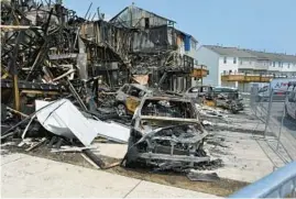  ?? ?? Melted vehicles sit among the pile of debris after the blaze. The fire reportedly displaced 19 adults and seven children, as well as three dogs and three cats.