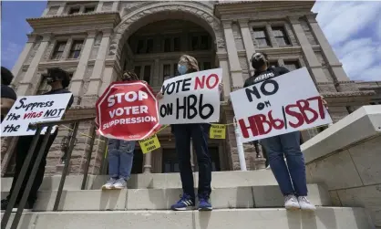  ?? ?? People opposed to Texas voter bills HB6 and SB7 hold signs on the steps of the state capitol in Austin on 21 April. Photograph: Eric Gay/AP