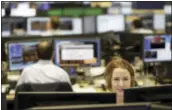  ?? MARK LENNIHAN — THE ASSOCIATED PRESS ?? In this photo, traders work on the Mizuho Americas trading floor in New York. U.S. stocks took their biggest loss in five months Tuesday as a health care bill backed by President Donald Trump ran into trouble in Congress.