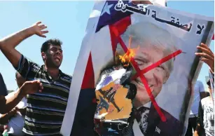  ?? (Ibraheem Abu Mustafa/Reuters) ?? PALESTINIA­NS BURN a picture of US President Donald Trump during a protest in the Gaza Strip against the Bahrain workshop.