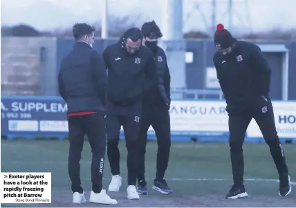  ?? Steve Bond/Pinnacle ?? Exeter players have a look at the rapidly freezing pitch at Barrow