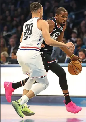  ?? STREETER LECKA — GETTY IMAGES ?? Warriors superstar Kevin Durant, right, playing for Team LeBron, drives against Stephen Curry of the Warriors and Team Giannis in the first quarter of the NBA All-Star Game at Spectrum Center on Sunday in Charlotte, North Carolina.