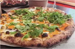  ?? HEATHER HUNTER/ FOR THE JOURNAL ?? Pizza Chimayó with roasted garlic, Boar’s Head bacon, wood fired chicken, Chimayó red chile crema and arugula at HAWT Pizza.