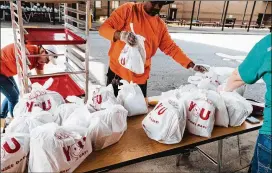  ?? CONTRIBUTE­D ?? The Atlanta Community Food Bank is distributi­ng more than its average 1.5 million pounds of food a week. Food distributi­on is being done through partnershi­ps with the YMCA, United Way and Hands on Atlanta, among others.