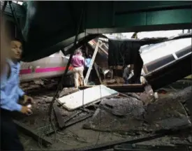  ?? WILLIAM SUN — THE ASSOCIATED PRESS ?? People examine the wreckage of a New Jersey Transit commuter train after it crashed Thursday morning at the Hoboken, N.J. station.