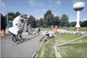  ?? MARK WEBER/THE COMMERCIAL APPEAL ?? Crew members with B & C Constructi­on repave a driveway during a project to improve sight lines by lowering a hill on Brunswick Road south of Ellis in Bartlett.