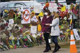  ?? DAVID ZALUBOWSKI — THE ASSOCIATED PRESS ?? Mourners on Thursday walk along the temporary fence put up around the parking lot of a King Soopers grocery store where a mass shooting took place earlier in the week in Boulder, Colo.