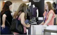  ?? THE ASSOCIATED PRESS ?? Cashier Liz Moore, right, checks out customers Christie Meeks, center, and Lisa Starnes, left, at a Kohl’s store in Concord, N.C.