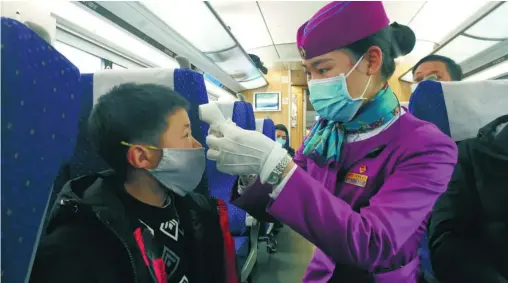  ??  ?? El 2 de febrero, en el tren D354 desde Chengdu Este a Hongqiao de Shanghai, una empleada del tren comprobó la temperatur­a corporal de los niños. (Hu Zhiqiang/ vip.people.com.cn)