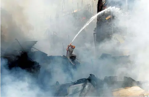  ??  ?? INDIA TODAY photograph­er Mandar Deodhar’s picture of a man trying to save his shop from a raging fire at a Mumbai market in November 2011 won the prestigiou­s ‘ Picture of the Year Award’ at a press photo contest organised by the Media Foundation of...