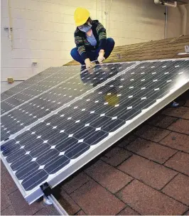  ??  ?? CNM student Ashlee Simpson tightens down a solar panel in a CNM photovolta­ics class Feb. 10.