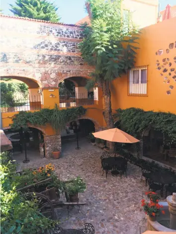  ?? Kim Curtis / AP ?? Courtyard gardens in San Miguel de Allende hide behind nondescrip­t, weathered brick facades.