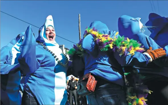  ?? BRYNN ANDERSON / AP ?? A woman dressed as a dolphin laughs as she dances in a dolphins themed parade that moves through the streets of New Orleans during Mardi Gras on Feb 9, 2016 in New Orleans.