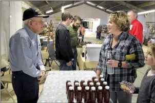  ??  ?? Lindsay Henry of Star City and her daughter, Corrine, visit with Elvin Bates of Drew County at a homesteadi­ng conference on April 1 in Rison. Bates has been a beekeeper for most of his life — he’s 98 — and was at the conference to share his knowledge...