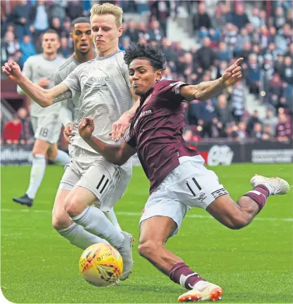  ??  ?? Aberdeen’s Gary Mackay-Steven attempts to tackle Hearts’ Demetri Mitchell