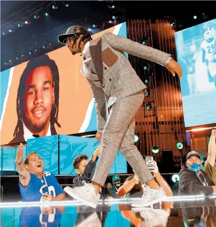  ?? GREGORY SHAMUS/GETTY ?? Jaylen Waddle walks onstage after getting picked sixth by the Dolphins in the NFL draft on Thursday in Cleveland, Ohio.