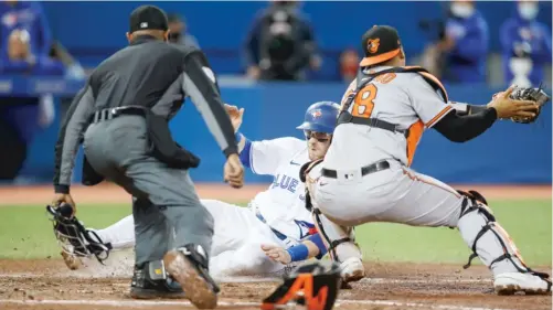  ?? GETTY IMAGES ?? Danny Jansen slides across the plate before the tag of Orioles catcher Pedro Severino during the Blue Jays’ four-run outburst in the sixth inning Friday night.