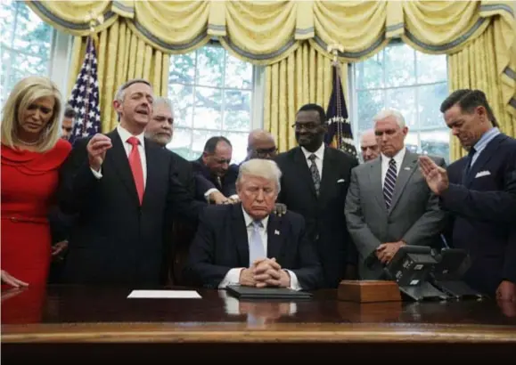  ?? FOTO GETTY IMAGES ?? President Donald Trump is letterlijk en figuurlijk omringd door een aantal zeer gelovige kabinetsle­den.