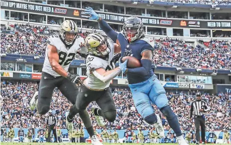  ?? AP ?? New Orleans Saints defensive end Marcus Davenport (92) and linebacker Pete Werner pursue Tennessee Titans running back D'Onta Foreman during their game Sunday. Foreman had 11 carries for 30 yards and also caught two passes.
