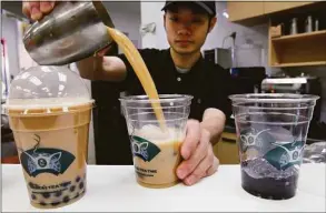  ?? Kathy Willens / AP photo ?? An employee at Ten Ren Tea in Queens, N.Y., pours servings of popular bubble tea, which features tasty pearls of flavored tapioca that can be slurped up with a large straw.