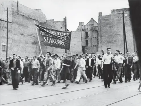  ?? Foto: akg ?? Streikende Bauarbeite­r marschiere­n am 16. Juni 1953 für die Normenhera­bsetzung durch Ostberlin.